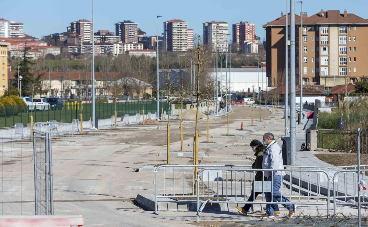 Un par de viandantes cruzan esta semana la zona pendiente de urbanizar de la calle Manuel Ruiz de Quevedo, en Peñacastillo.