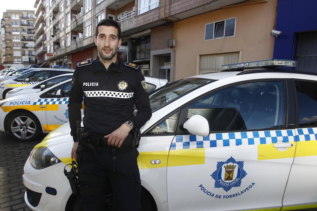 David Bustos junto a varios coches de la Policía Local, a escasos metros de la Comisaría de Torrelavega. 