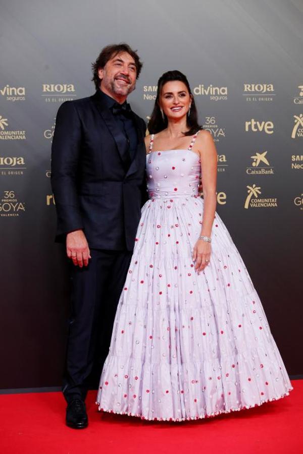 Los actores Javier Bardem y Penélope Cruz posan en la alfombra roja. Una de las presencias más esperadas de este año ha sido la de Penélope Cruz que ha vuelto a confiar en Chanel para esta gran cita, ya que es una de sus embajadoras. Se trata de un diseño con bordados-joya y de estilo 'lady', perteneciente a la colección Alta Costura primavera-verano 2021. Tiene tirantes 'spaghetti', corpiño ceñido y falda con volúmen.