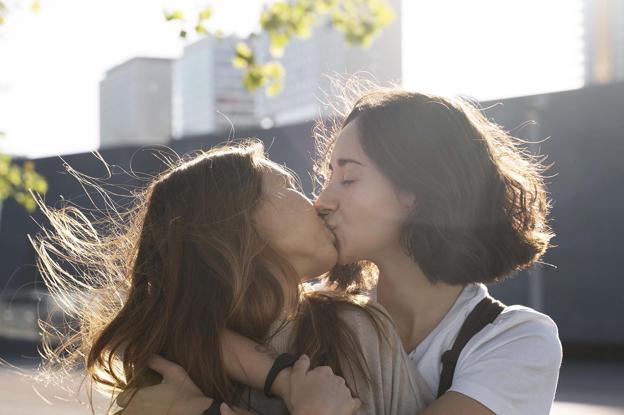 Dos chicas se besan, totalmente enamoradas.