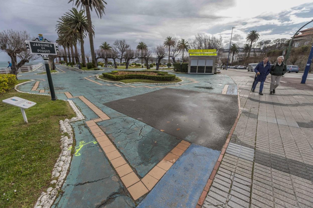 Dos hombres paseaban este pasado lunes junto al acceso a los jardines, con el pavimento deteriorado. 