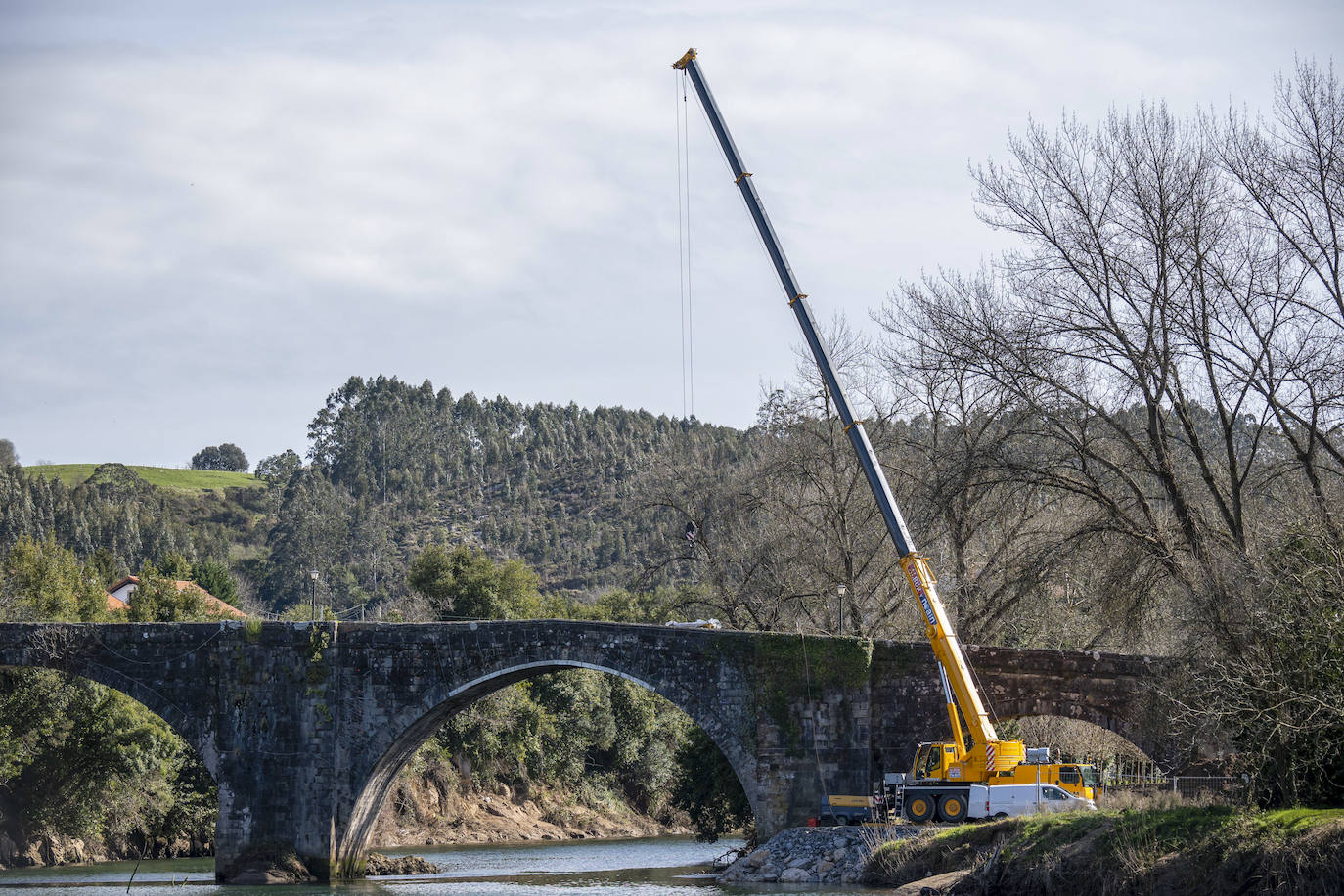 Los operarios que trabajan en la reparación del puente utilizan una grúa para mover el material y para acceder a las zonas más complicadas.