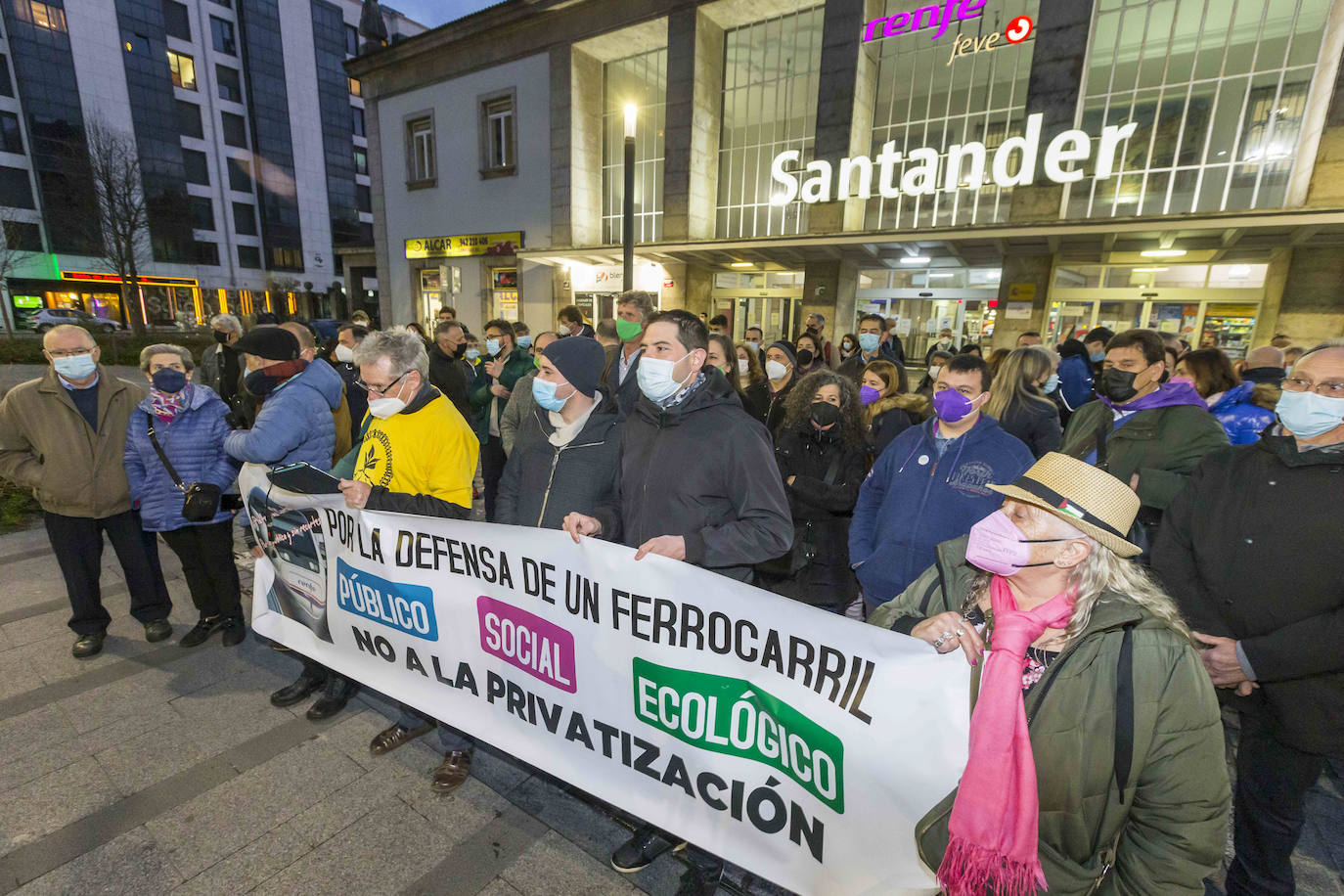 Los convocantes portan una pancarta frente a la estación de tren. Los políticos se colocaron en un segundo plano. 