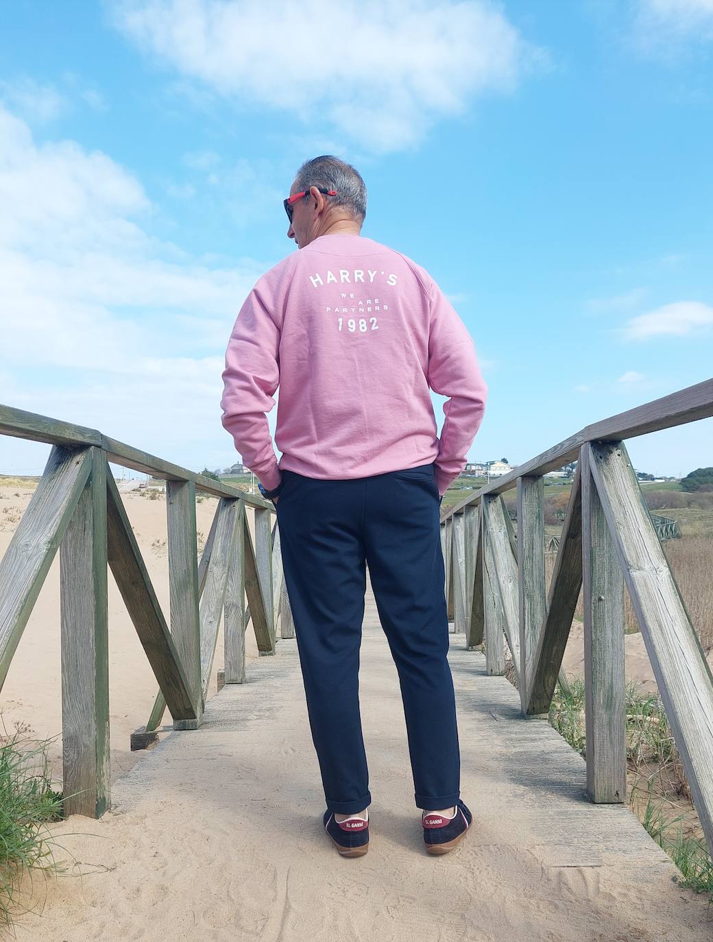 Las sudaderas de algodón se han adueñado del 'street style', no sólo para la práctica deportica. Como este look, con un diseño en rosa, combinado con pantalón chino azul y deportivas a juego.