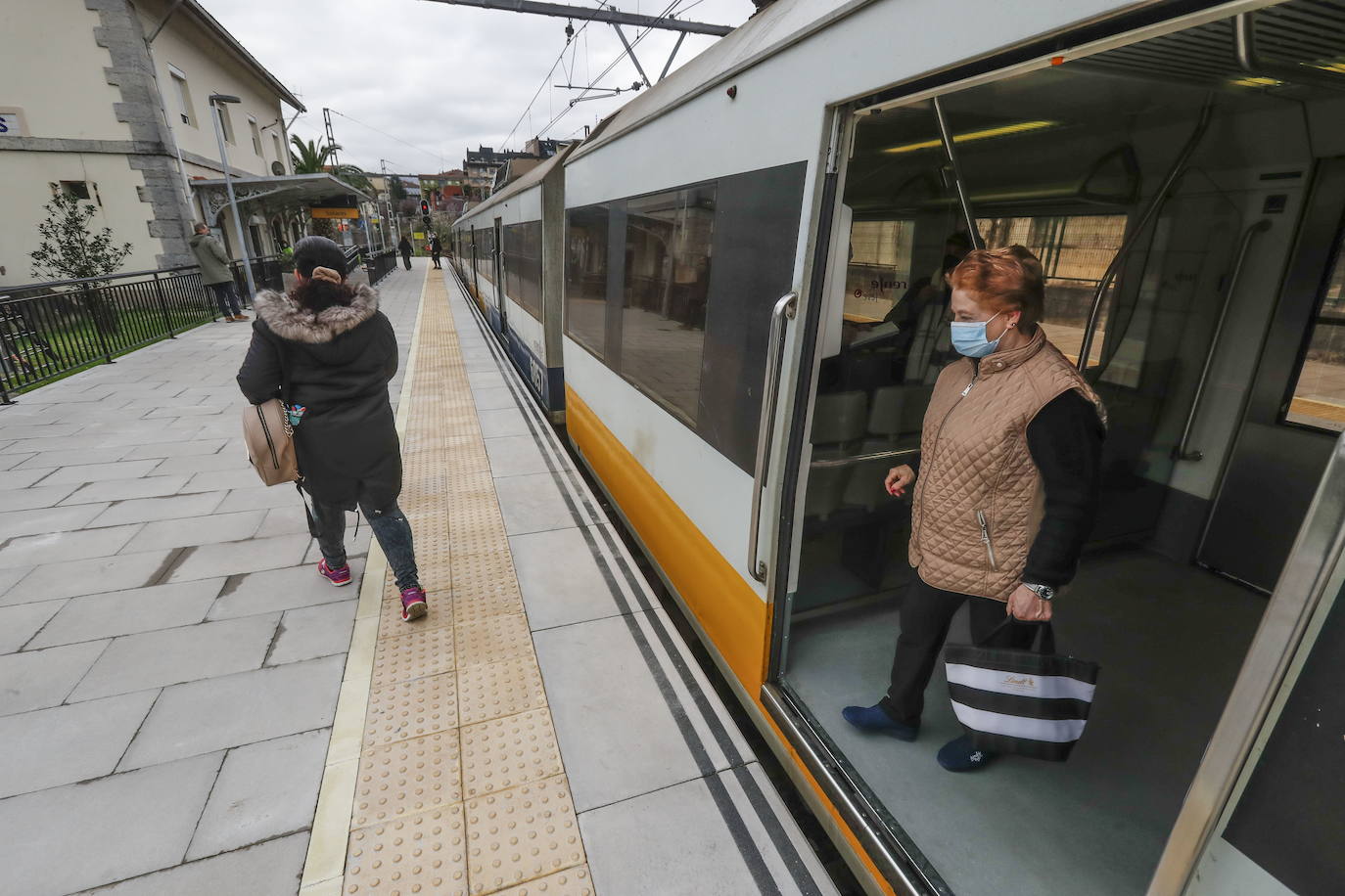 Dos viajeras se bajan del tren en la estación de Solares.