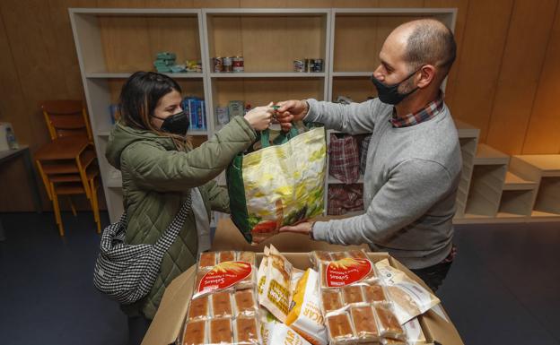 Helena Garay entrega a Luis Jorde, conserje del centro cívico del Río de la Pila, los productos donados.