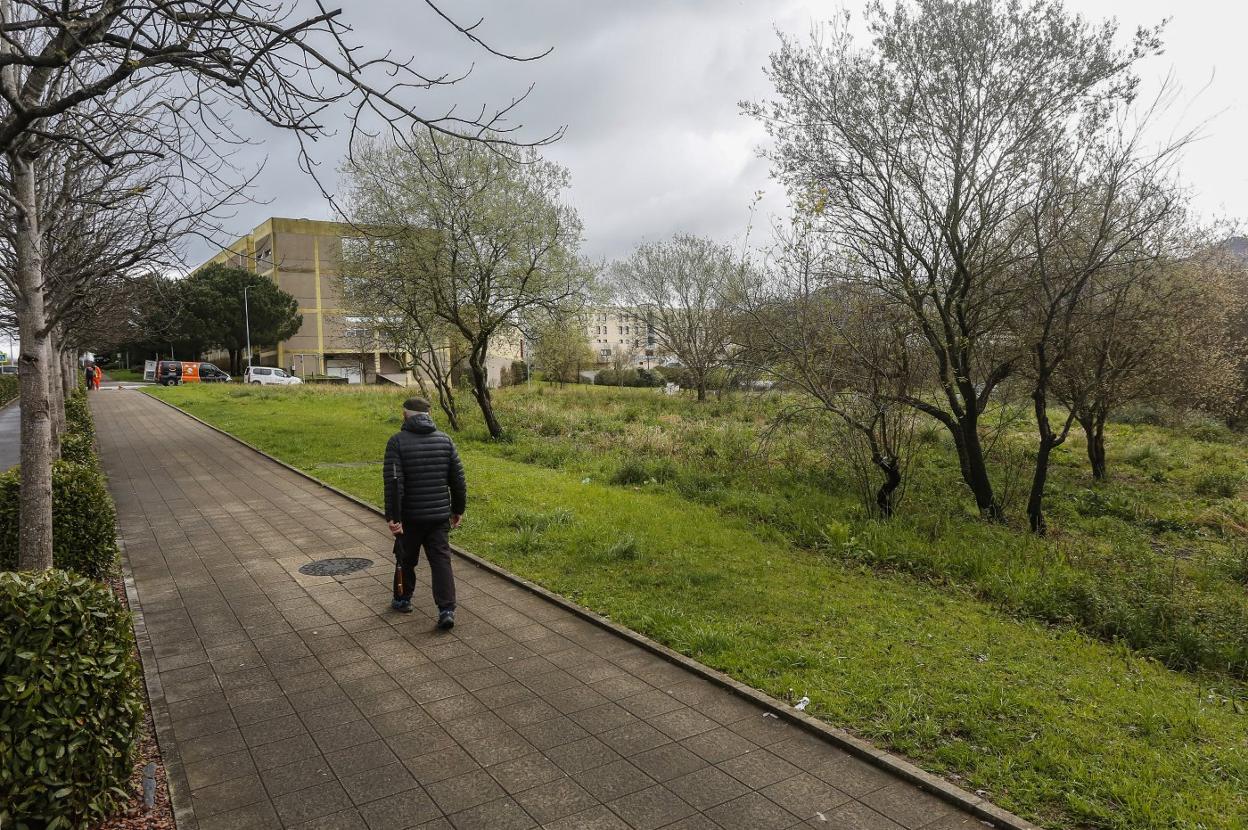 Un hombre camina junto a la parcela del campus universitario en la que se pretende ejecutar el proyecto.