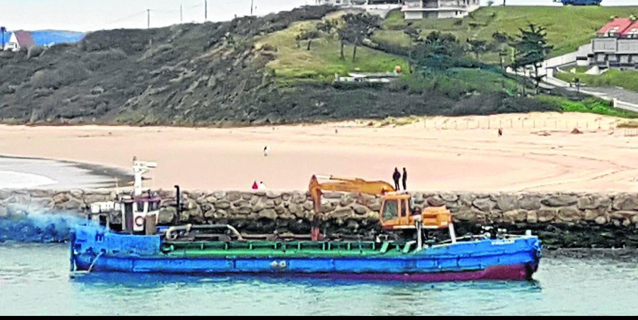 La draga ha comenzado a actuar en la entrada del canal de navegación, frente al rompeolas. 