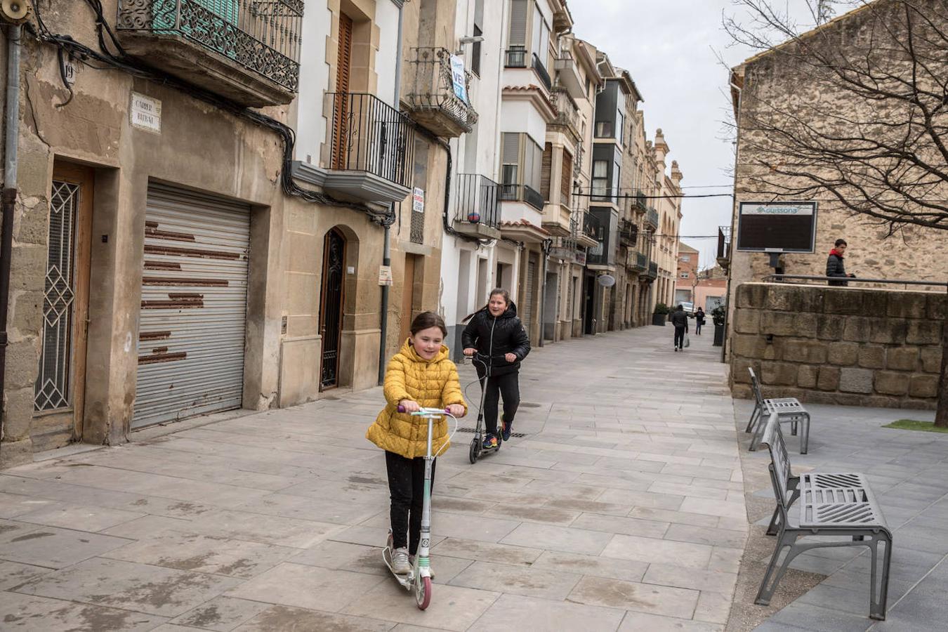 Sofía de 11 años, juega con su prima recién llegada Natalia, en la plaza del Ayuntamiento mientras su padre Sergey la empadrona a ella, junto a su hermano y madre en su casa.