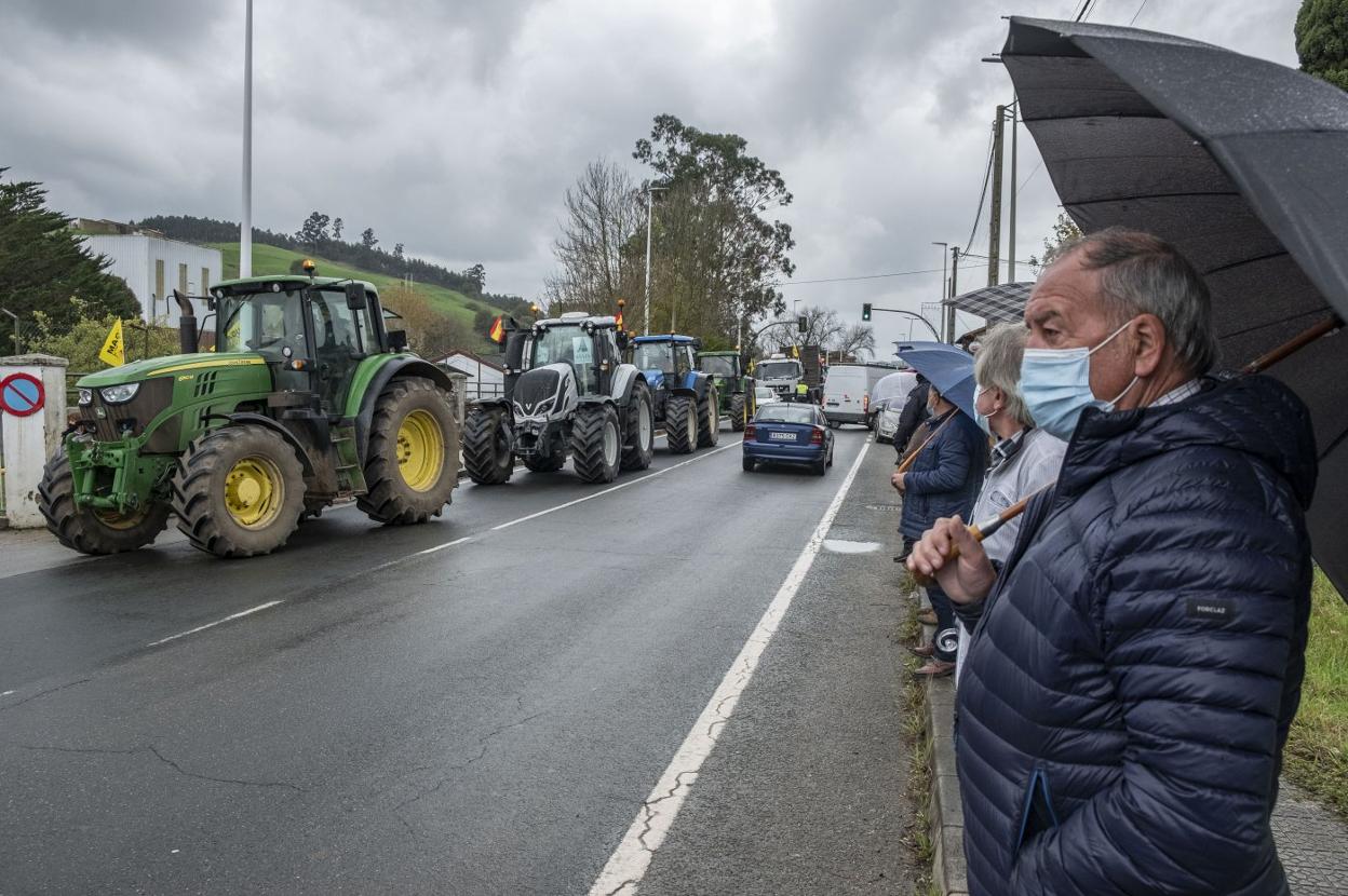 Los vecinos de Renedo de Piélagos observan una tractorada del sector ganadero. 