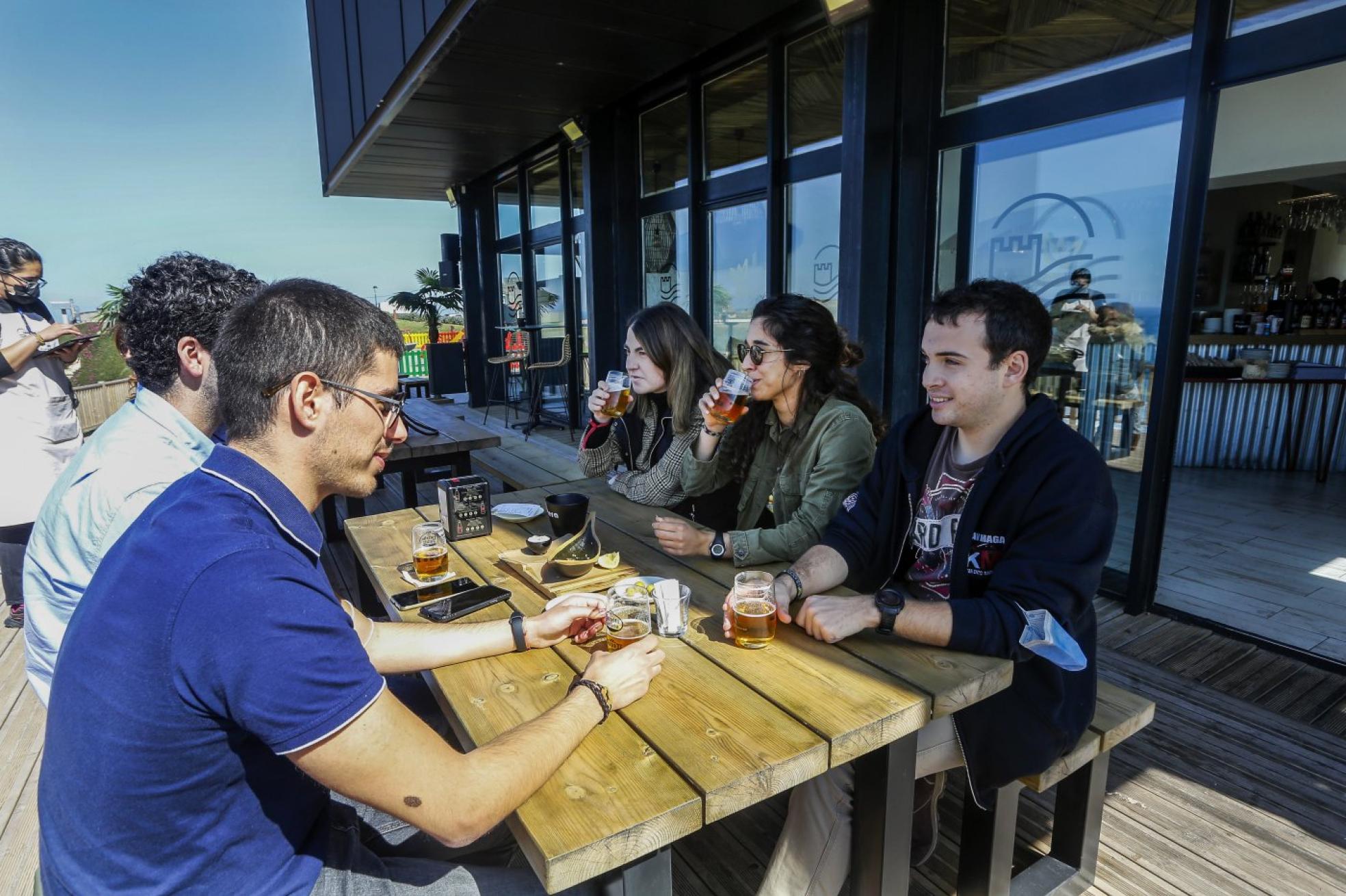 Un grupo de amigos toma unas cervezas en la terraza del hotel El Castillo de Suances. 