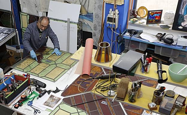 El artesano muestra diversas creaciones en su taller.