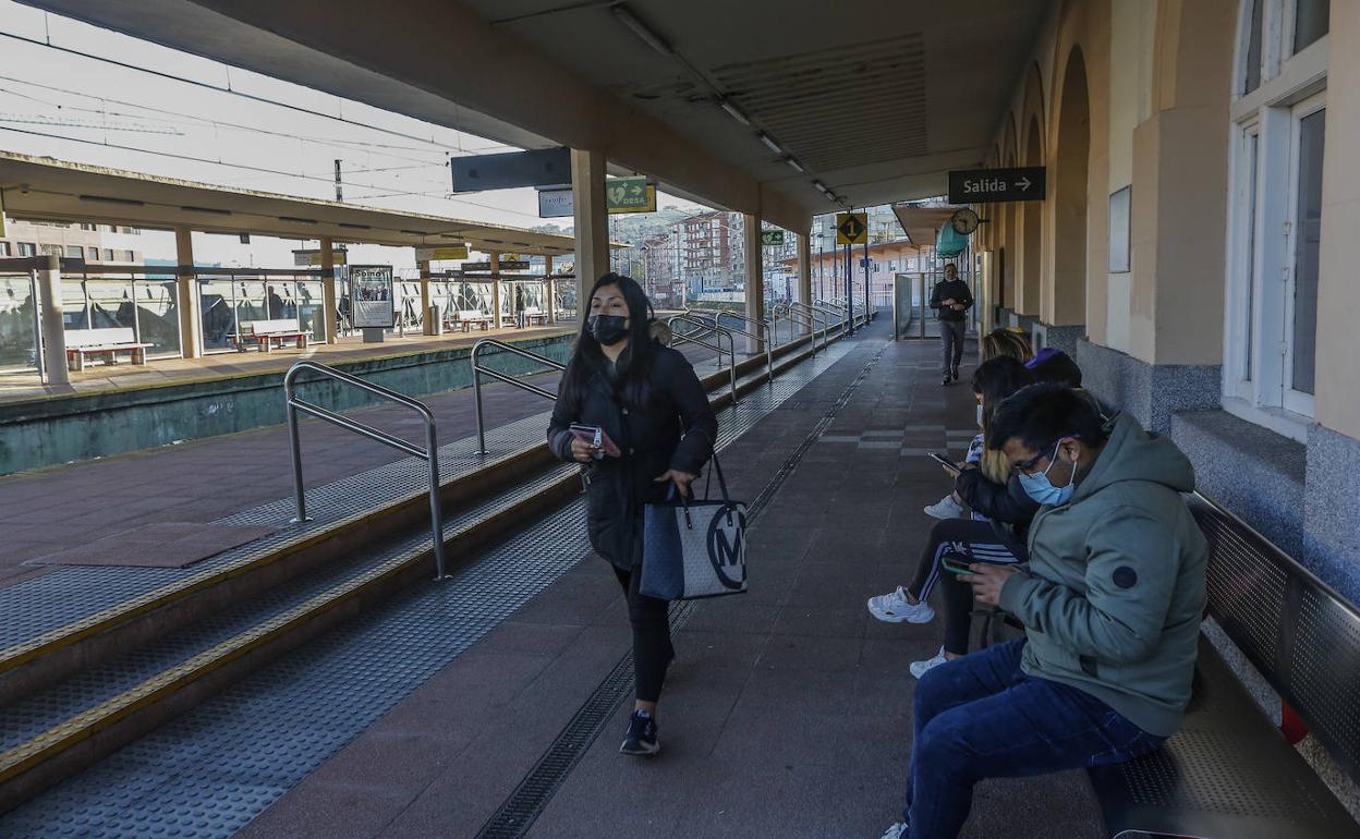 Varios pasajeros esperan, este martes, en la estación de Torrelavega a que llegue su tren después de una mañana marcada por el caos.