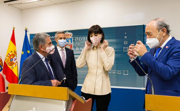 La ministra Morant se pone la mascarilla que le ha dado Revilla tras su intervención en el Gobierno de Cantabria, junto con Zuloaga y Marcano.