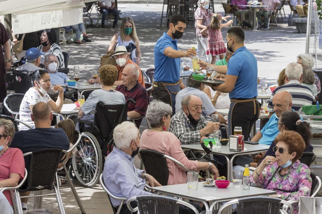 Dos camareros atienden una terraza en un establecimiento de Santander. 