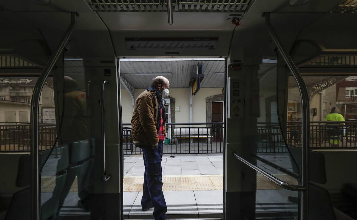 Un usuario de la red de cercanías de Cantabria espera en la puerta del tren antes de comenzar el trayecto