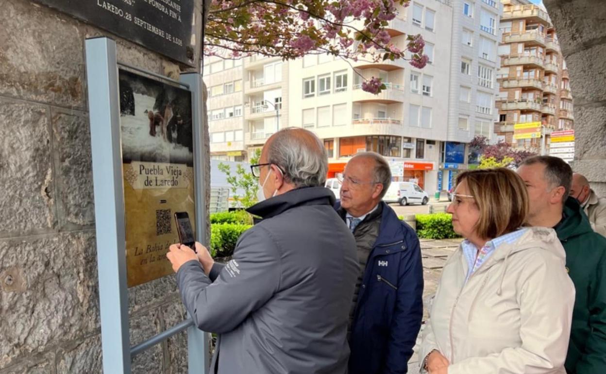 El consejero de Turismo comprueba el QR de uno de los paneles en presencia de la alcaldesa y otros ediles 