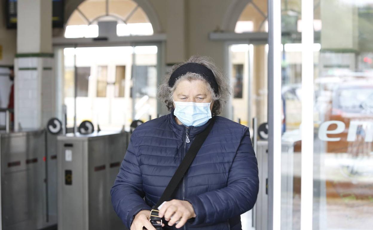 Una mujer, en la estación de renfe con mascarilla. 