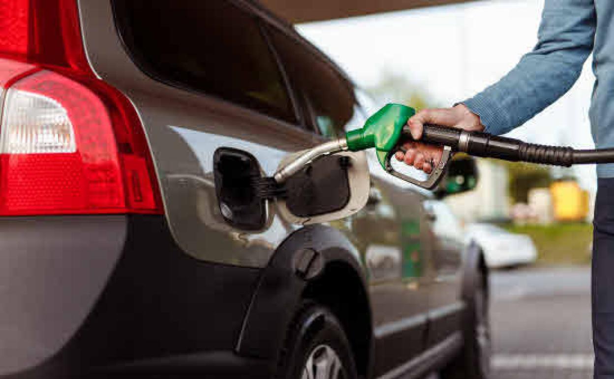 Un consumidor llenando el depósito de su coche. 