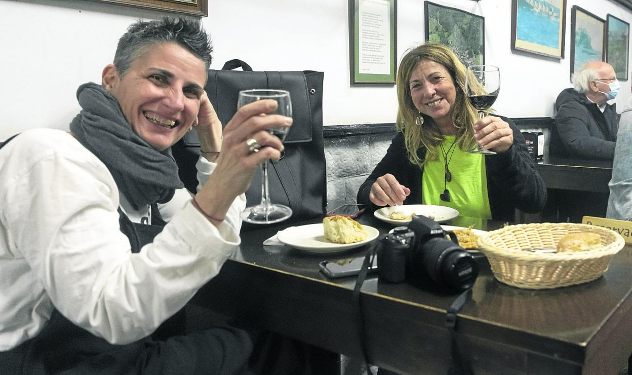 Dos mujeres brindan mientras pican algo de comer en la Bodega Fuente Dé, en Peña Herbosa. 