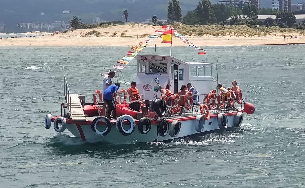 Los piragüistas descansan con el chaleco salvavidas abrochado junto a las embarcaciones ya izadas a bordo 