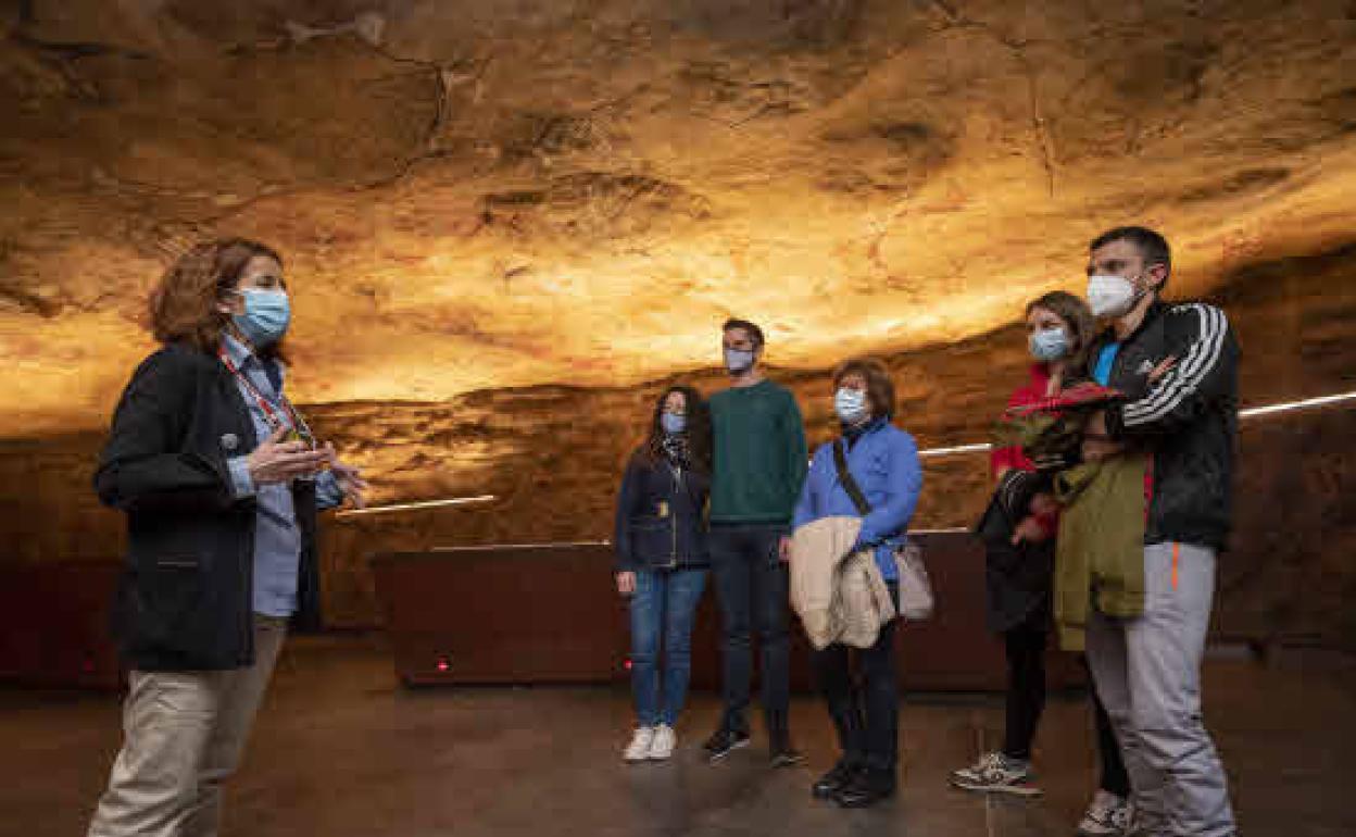 Una guía habla con los visitantes en la neocueva justo antes de una visita.