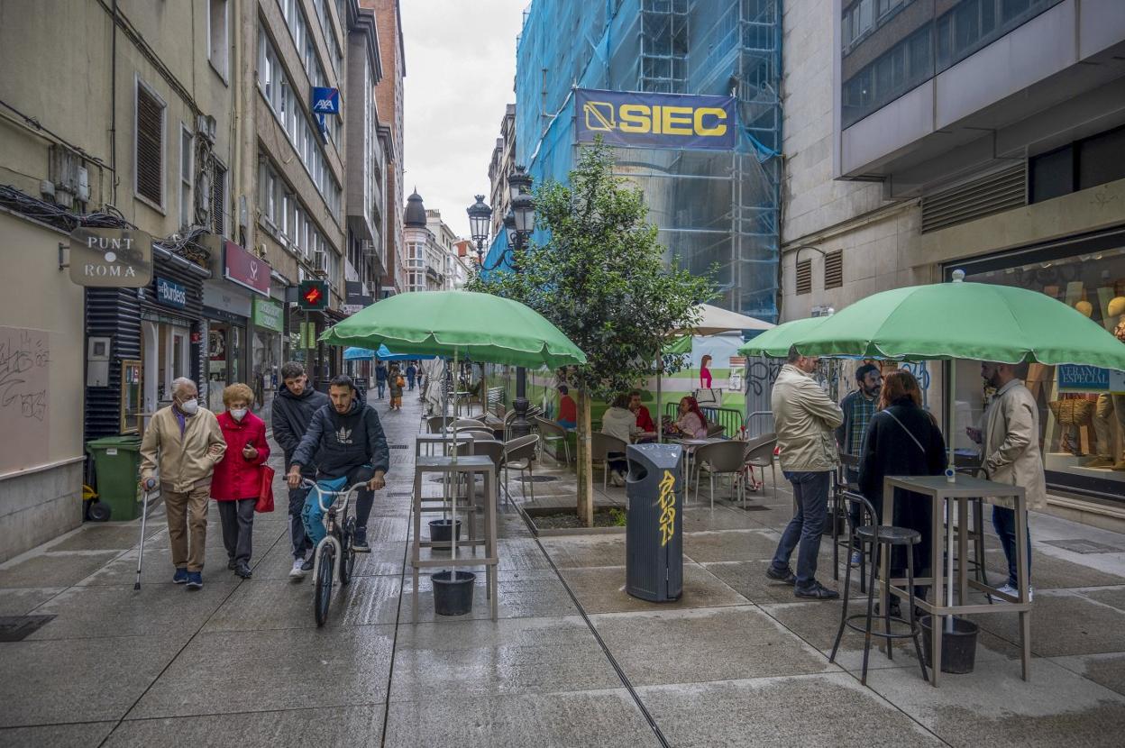 Las mesas que el Ayuntamiento permitió colocar en la calle Miguel Artigas de Santander para paliar el impacto de la crisis sanitaria en la hostelería continúan instaladas. 