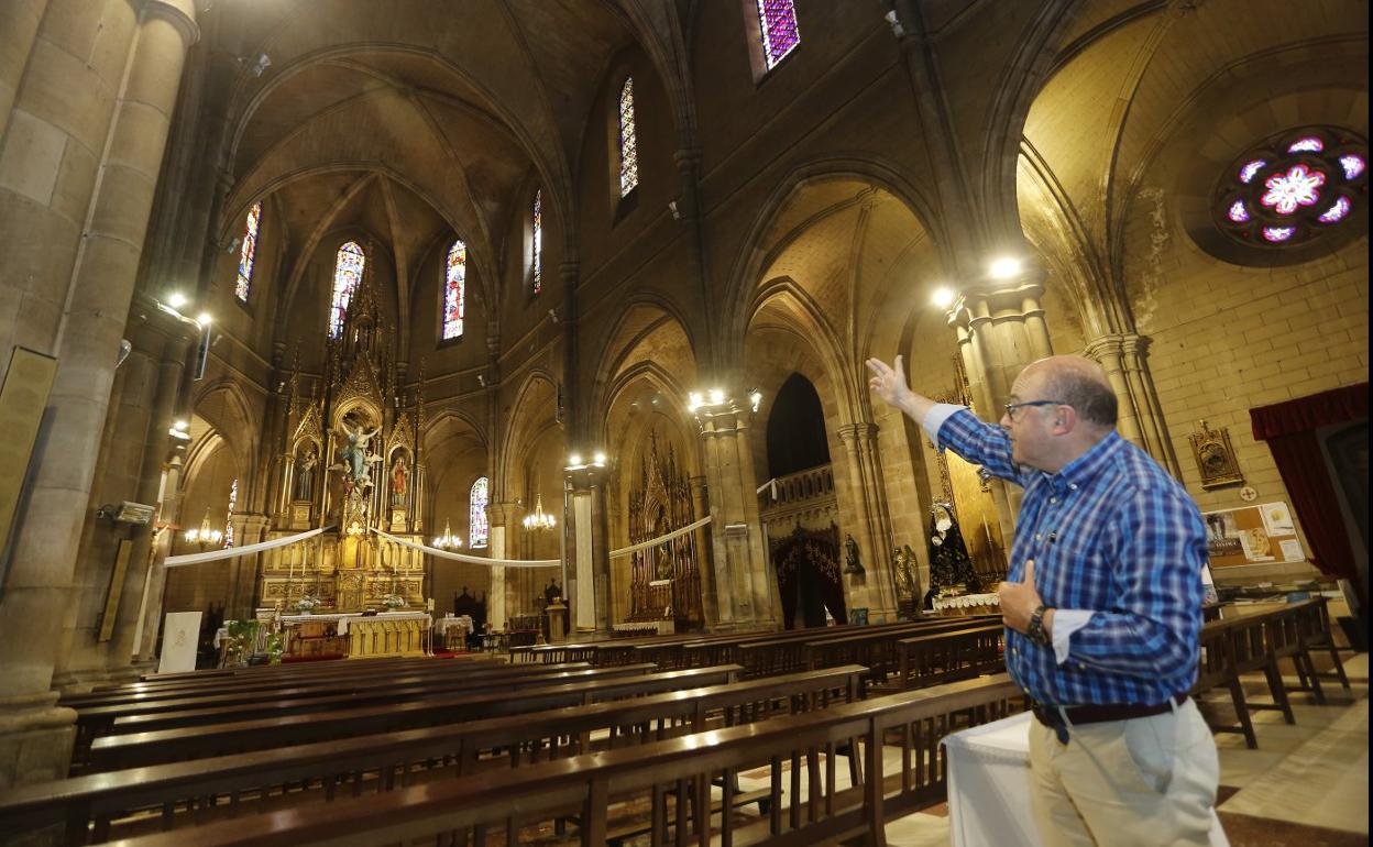 El párroco Juan Carlos Rodríguez del Pozo señala las vidriera de la iglesia, ayer, en La Asunción.