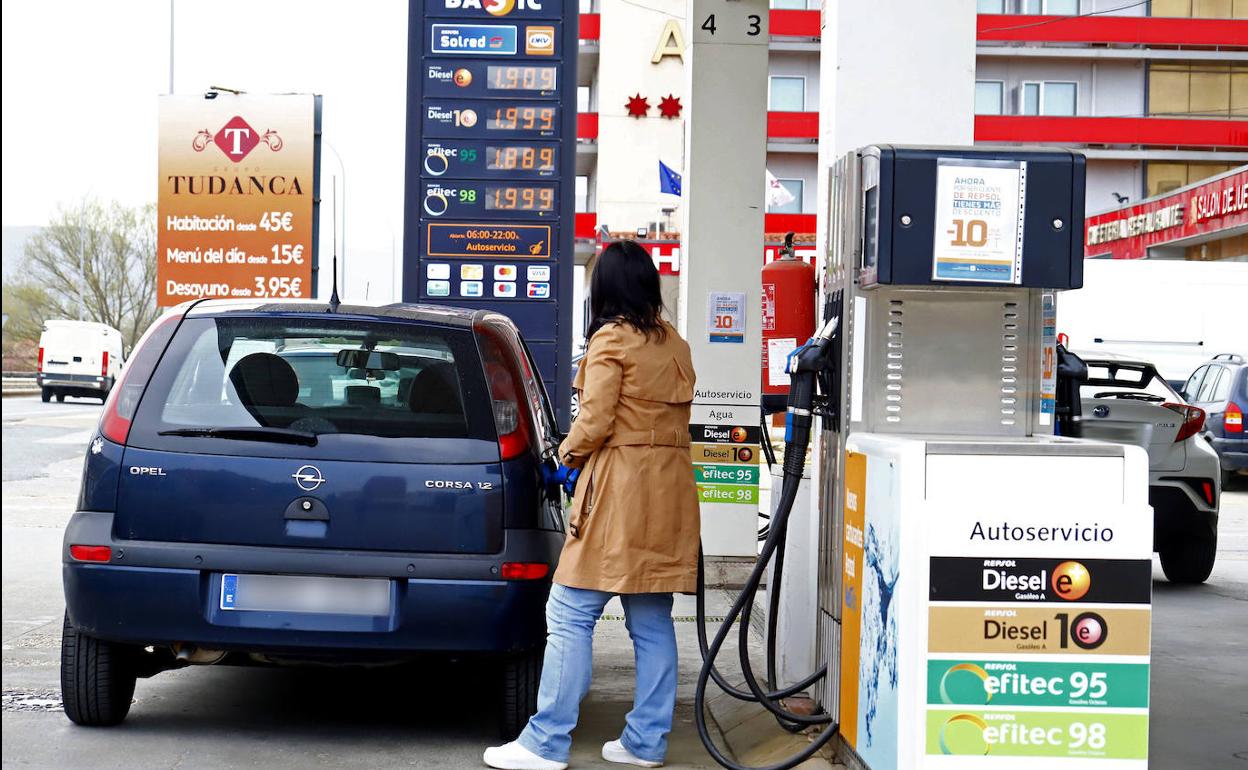 Una clienta reposta combustible en una gasolinera. 