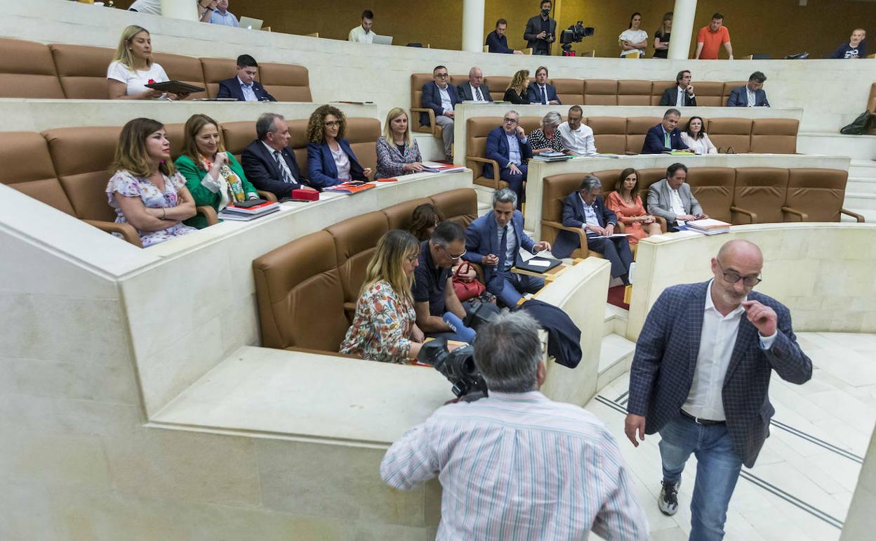 Felix Álvarez pasa por delante de los diputados socialistas en el pleno de este lunes en el Parlamento.