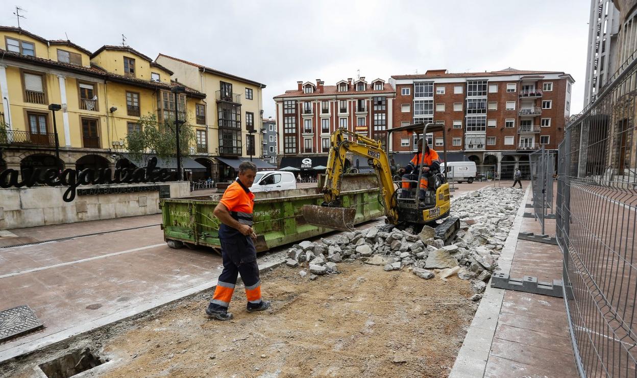 Dos operarios trabajan en la reparación de los daños en la plaza Baldomero Iglesias.