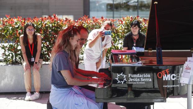 Uno voluntario toca el piano junto al ayuntamientp