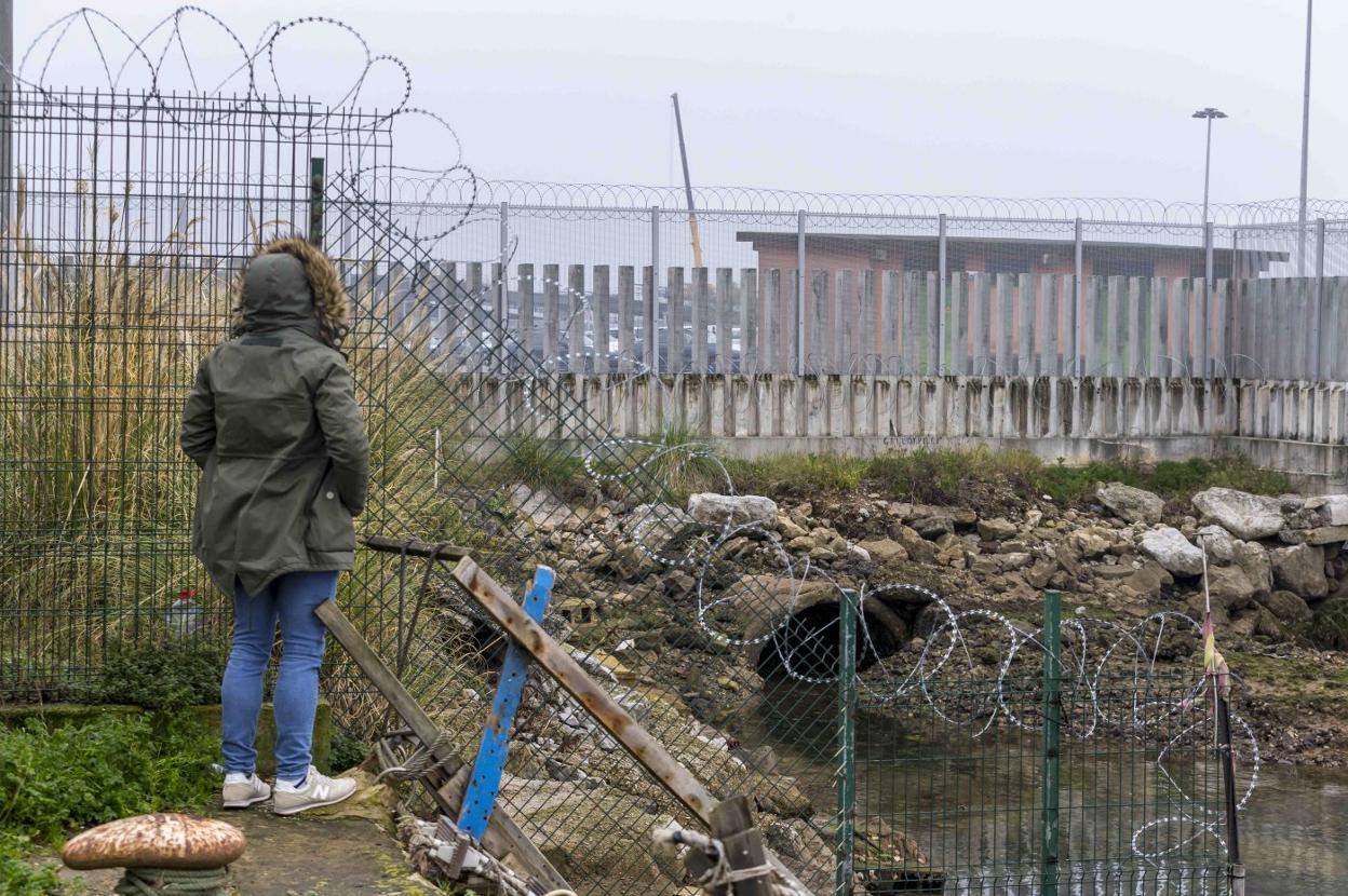 Un vecino de Santander mira las instalaciones portuarias junto a las concertinas.