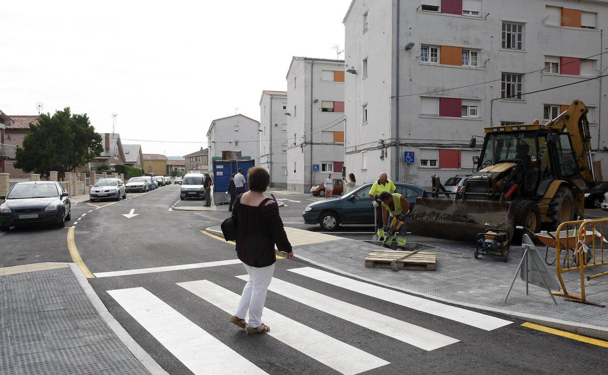 Una vecina cruza un paso de peatones para acceder al barrio de Insa.