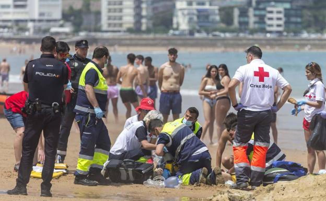 Los socorristas de la Cruz Roja tratan de reanimar a la mujer fallecida en la playa.