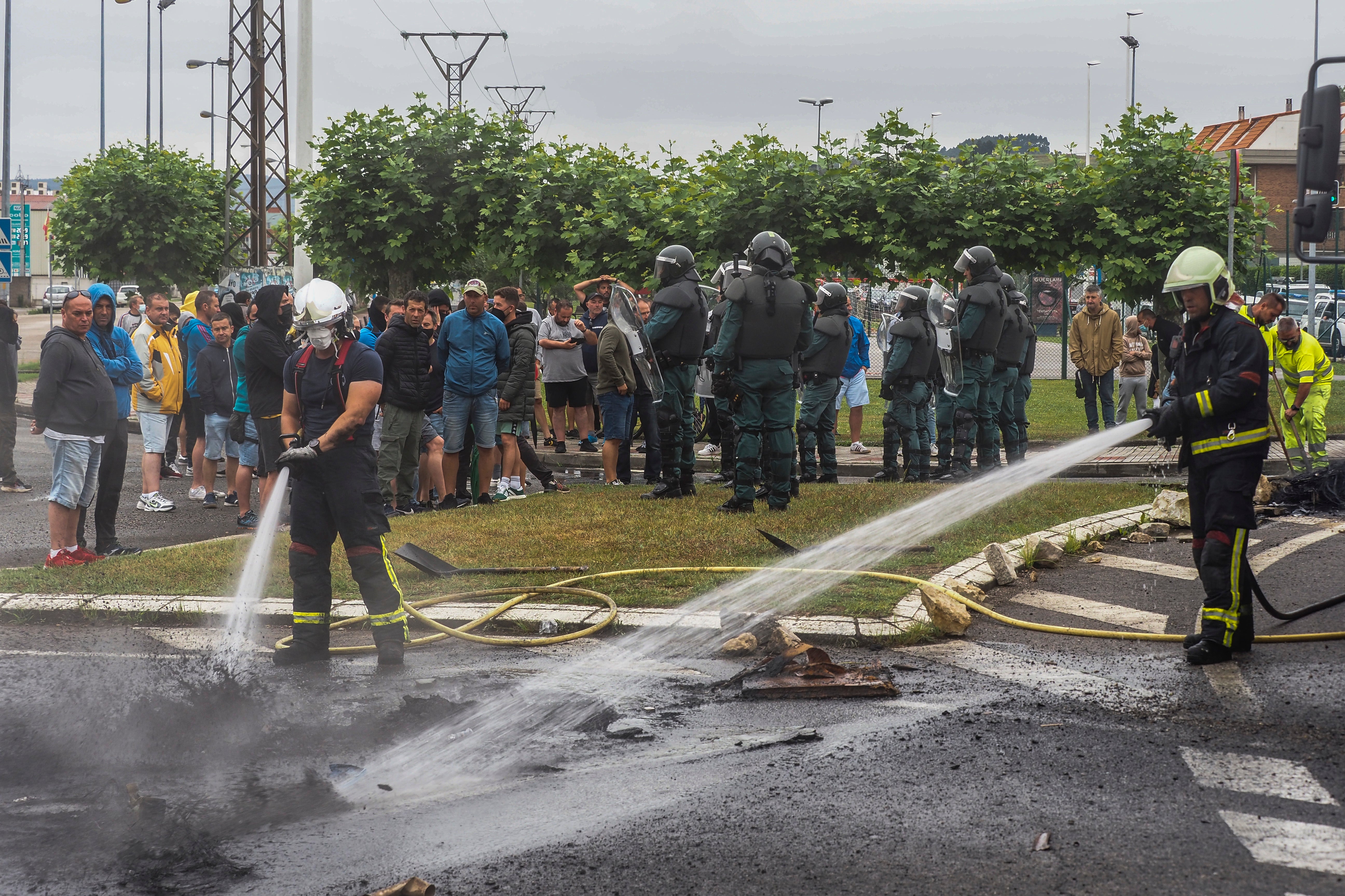 Los bomberos sofocan el fuego de las barricadas en los accesos del Polígono de Guarnizo.