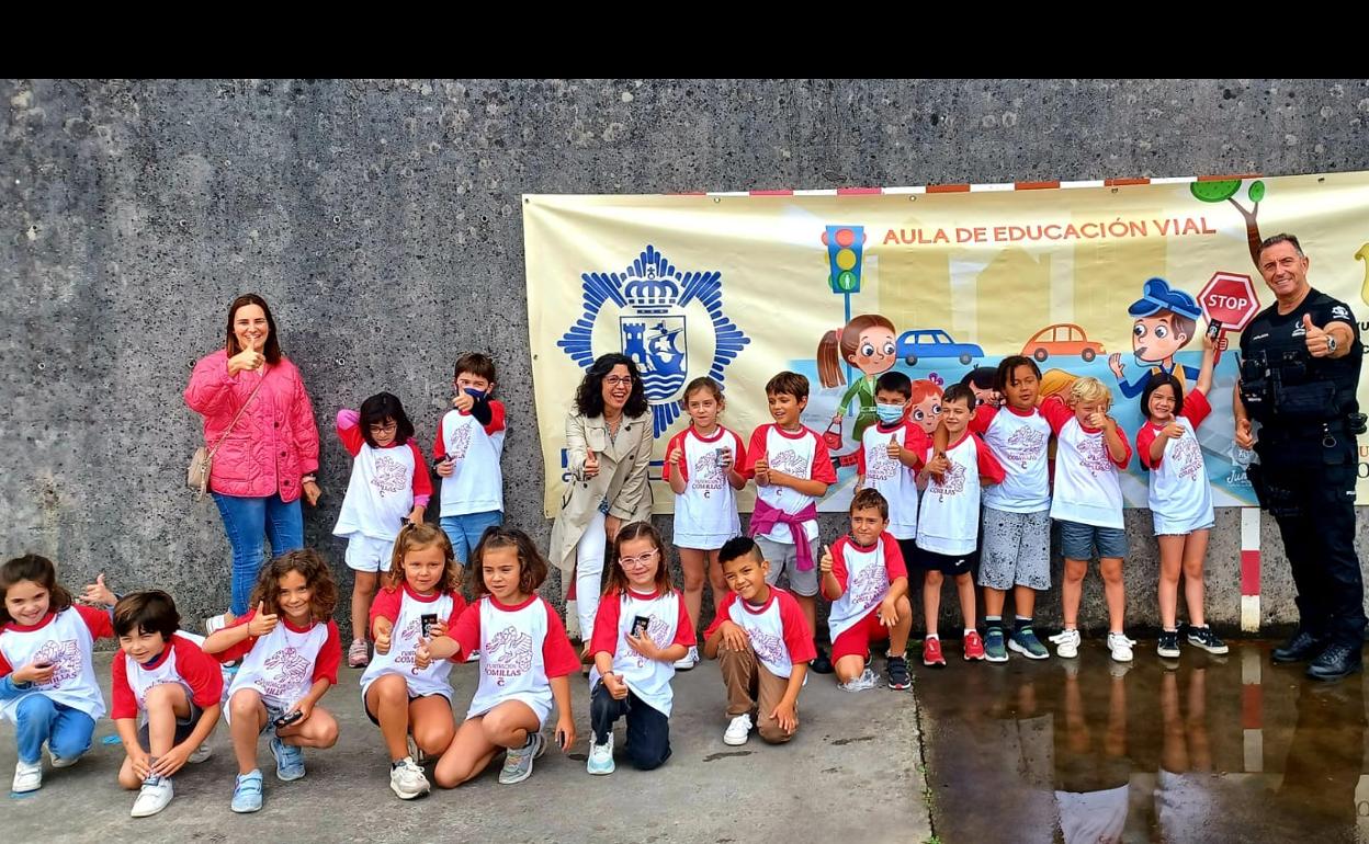 Escolares de Comillas posan junto al agente promotor del aula de educación vial. 