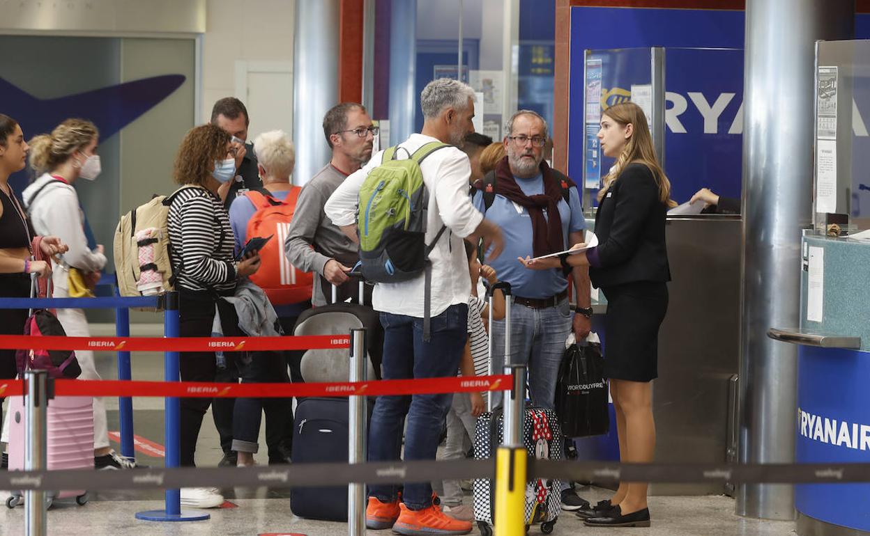 Varios pasajeros preguntan ayer a la azafata de Ryanair por las alternativas de viaje tras cancelarse el vuelo a Málaga. 