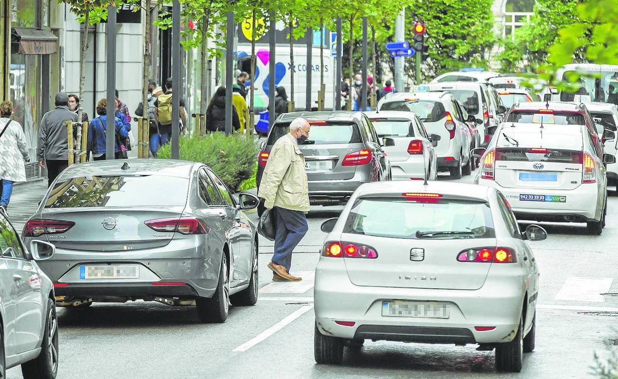 Un peatón cruza por un paso de cebra en la calle Isabel II, con densidad de tráfico. 