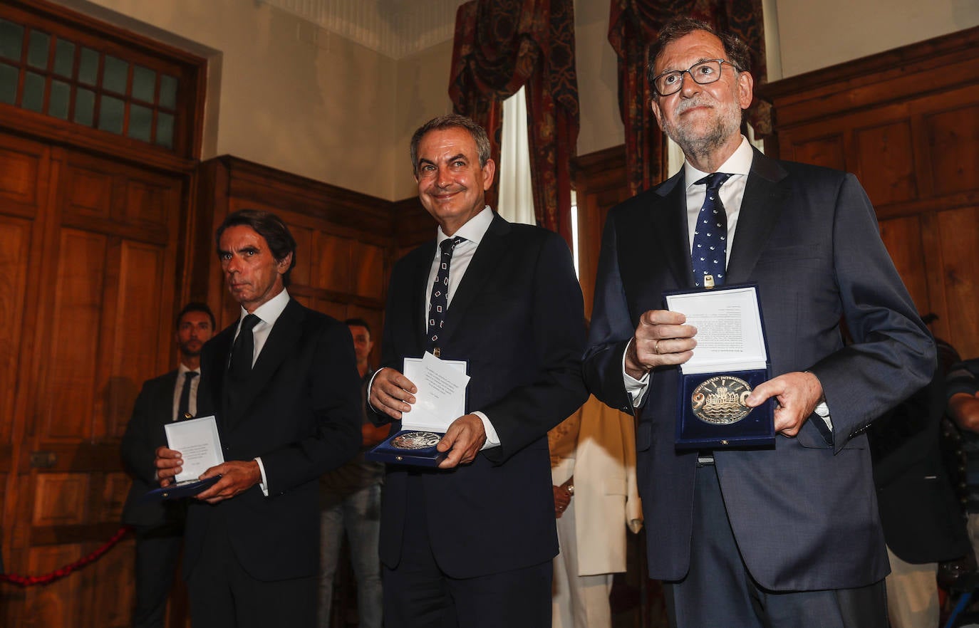 Los tres posan con la medalla.