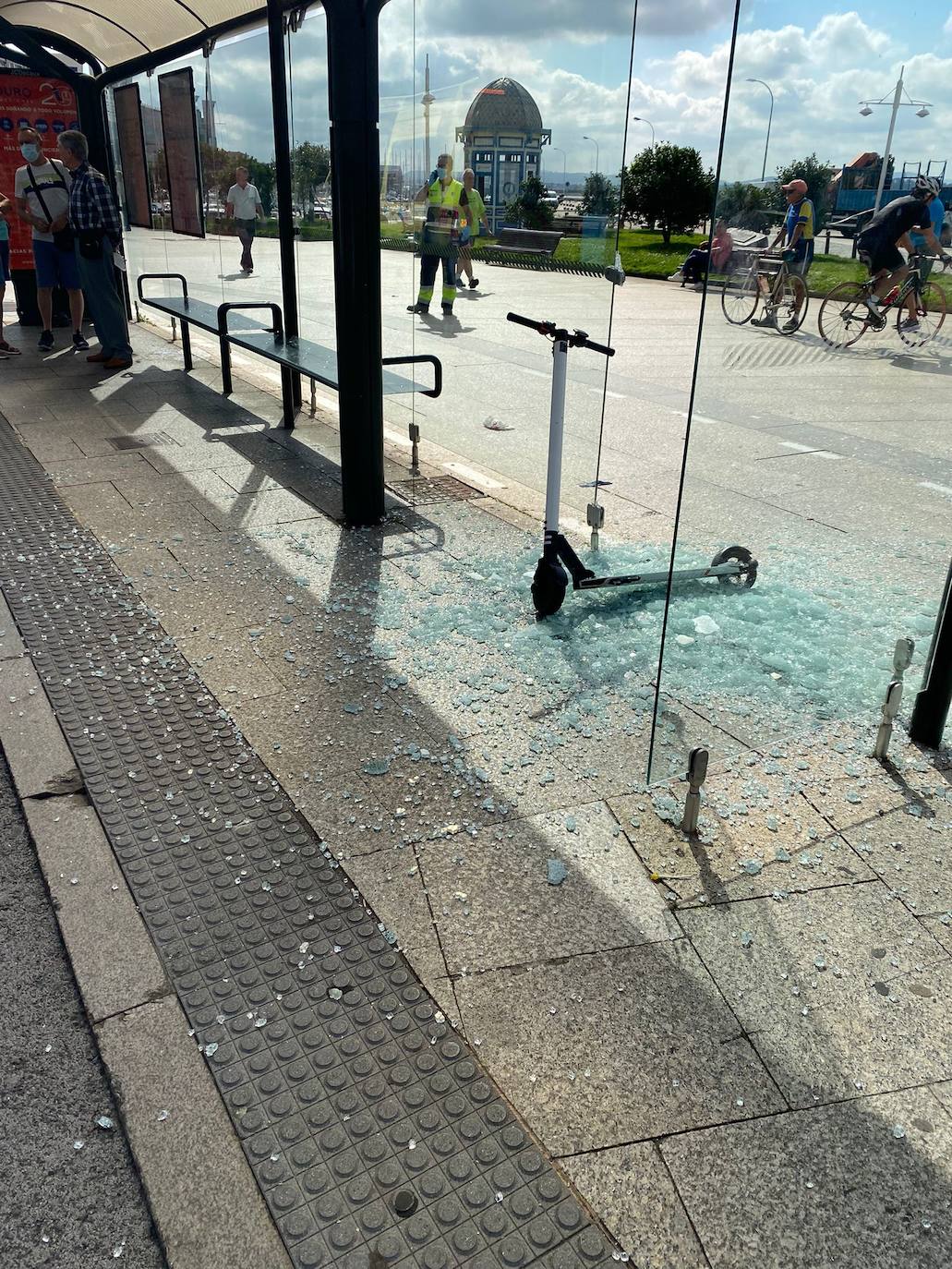 Operarios del Ayuntamiento de Santander han limpiado las inmediaciones de la marquesina de autobús en Puertochico, totalmente cubierta de cristales tras estrellarse una mujer que circulaba en patinete.