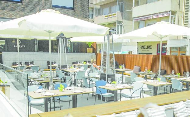 Terraza con zona de barra al fondo y gradas de madera. 