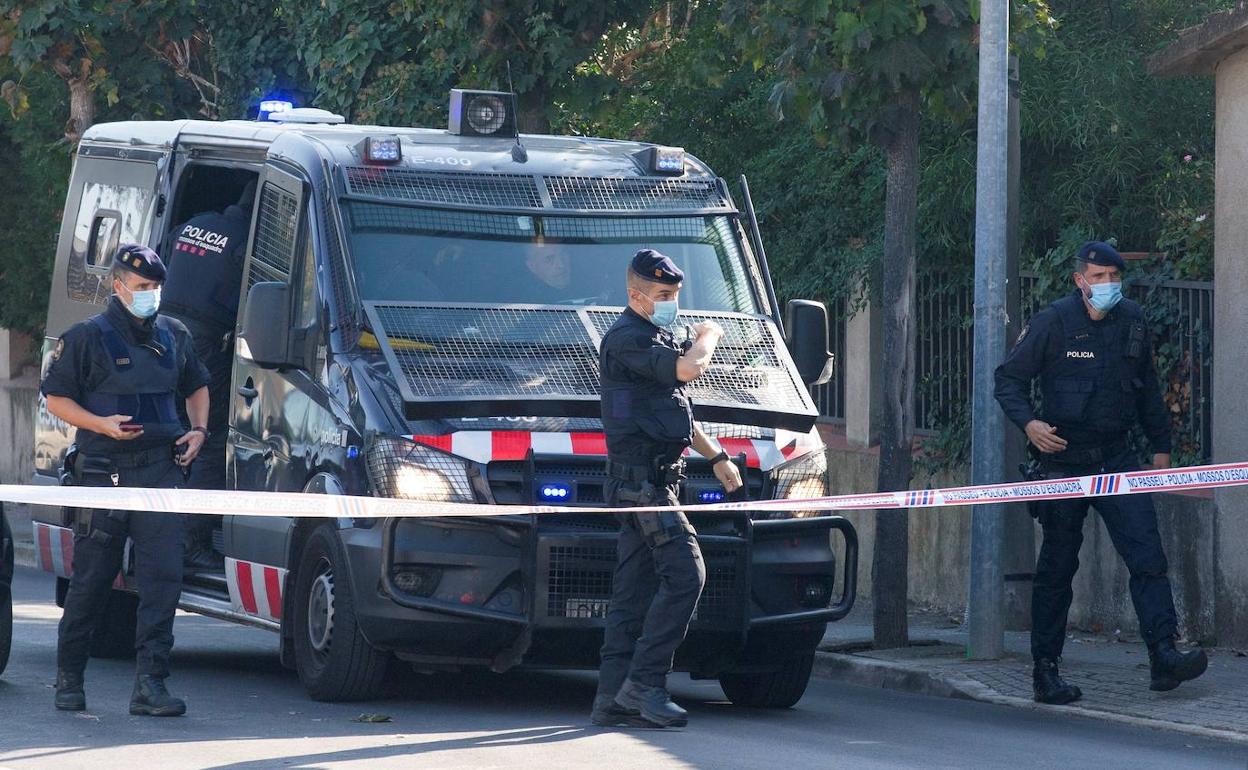 Varios agentes de los Mossos junto a una furgoneta policial.