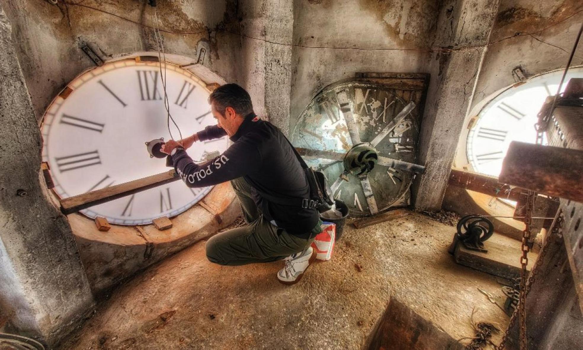 Carlos Herrero, relojero municipal, durante la restauración de una de las esferas del reloj de la iglesia de Los Carmelitas, en Santander. 