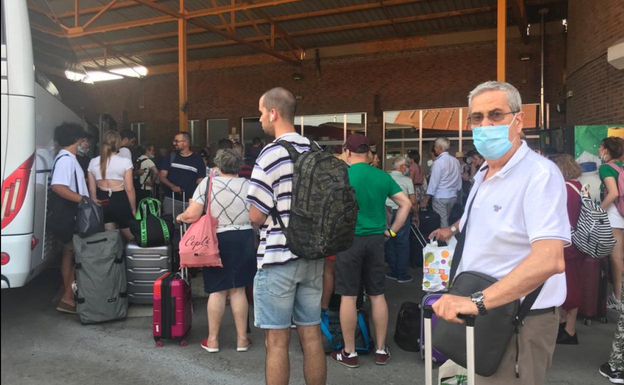 Pasajeros del Alvia aguardan para subirse a los autobuses que los trasladan a Torrelavega y Santander.