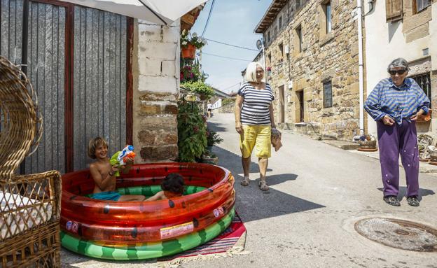 Enar y Niko juegan en una piscina hinchable en Bustillo del Monte, donde este miércoles apretó la ola de calor.