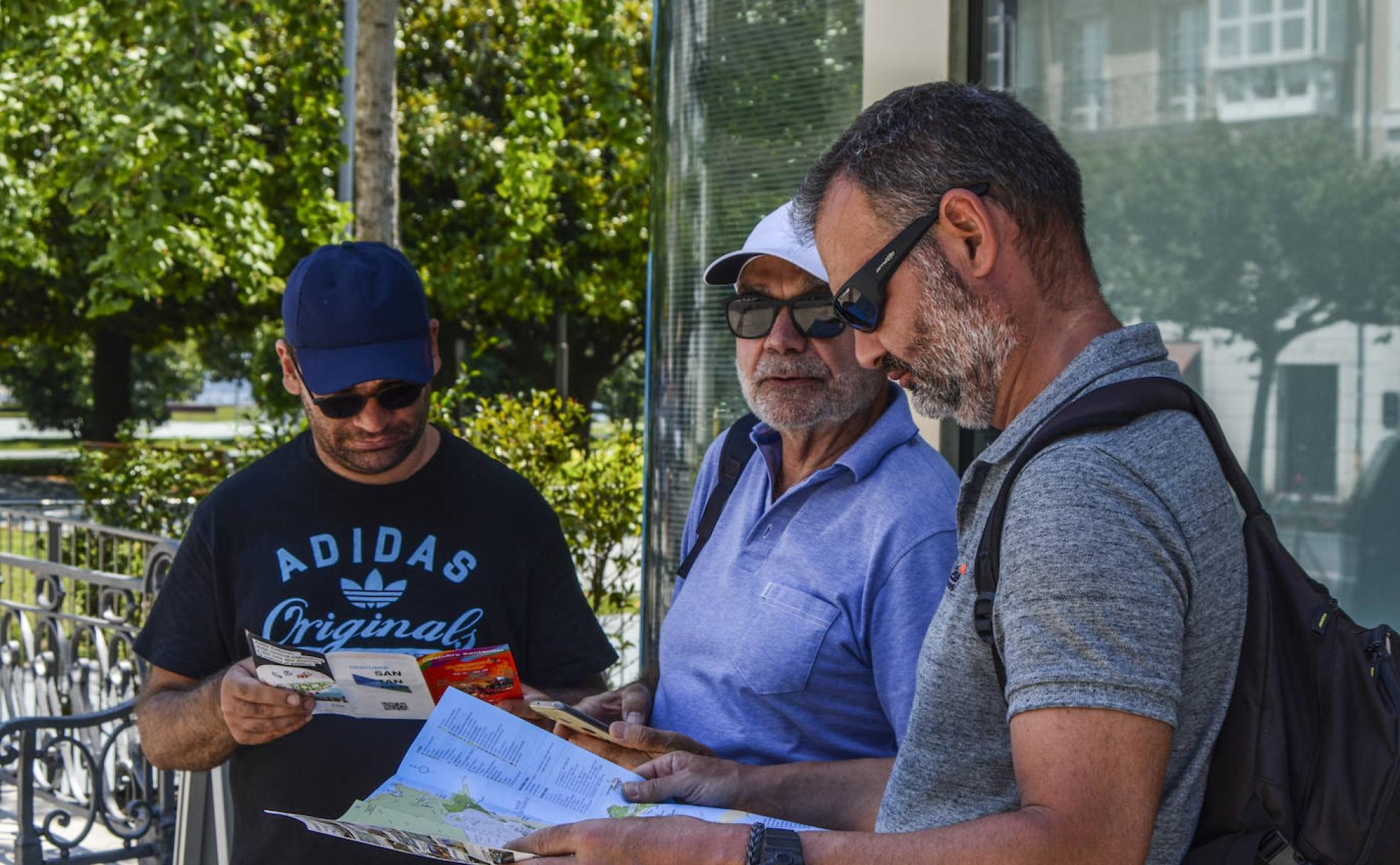 Un grupo de viajeros turísticos de la ciudad consulta uno de los planos.