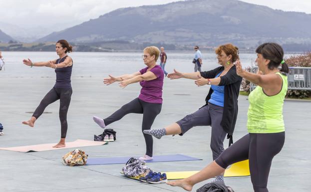 Unas señoras disfrutan de la sesión de yoga 'Yoguilate', impartida ayer junto al Centro Botín.