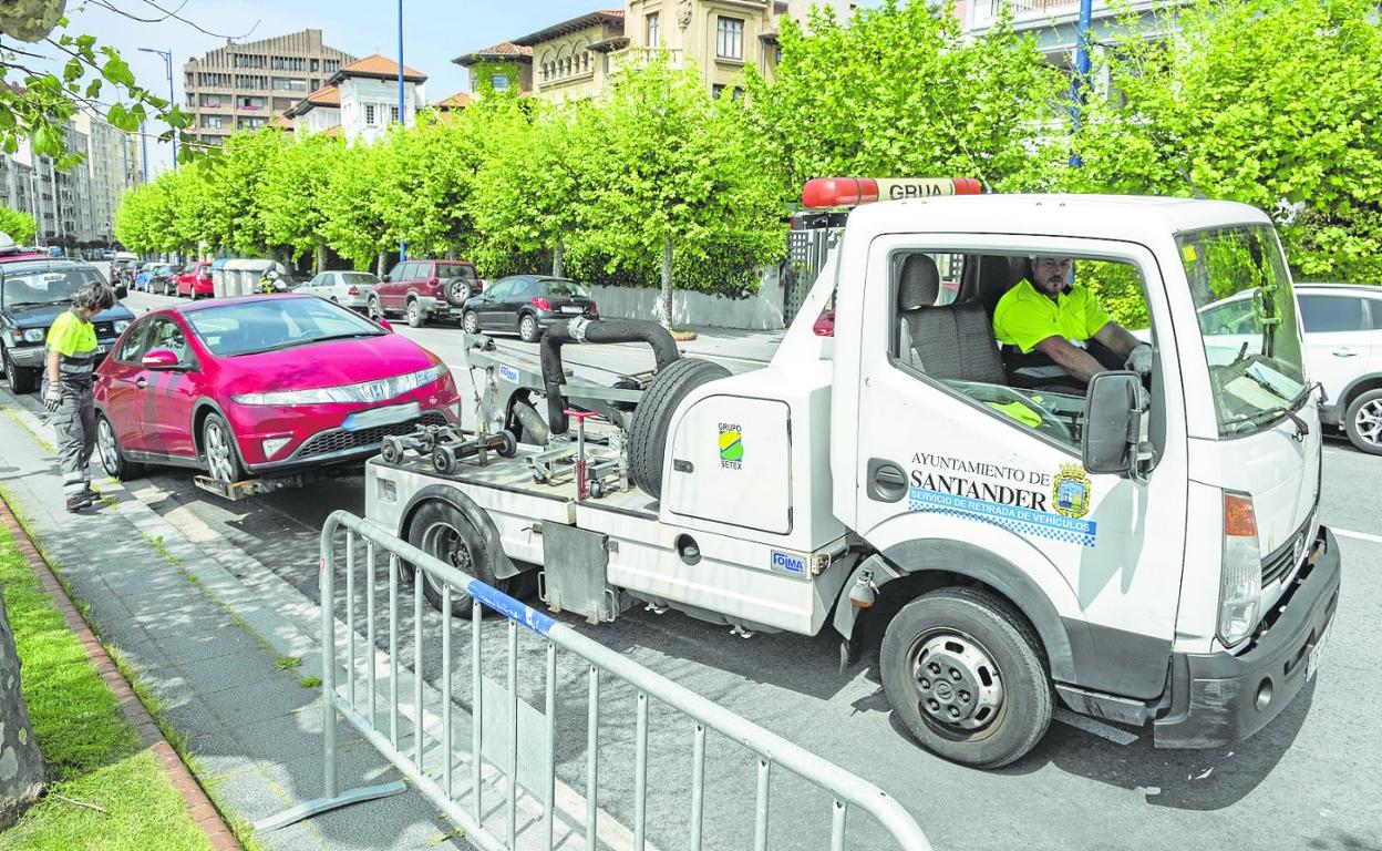 La grúa se lleva un coche mal estacionado en la avenida de Reina Victoria, en Santander. 