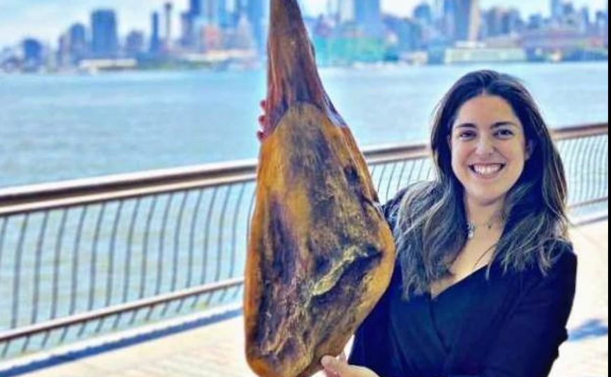 Laura García posa con un jamón con Nueva York al fondo. /